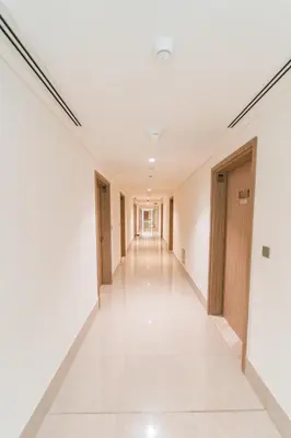 an empty corridor in a building with white walls and white floors at Wonderful Studio with Balcony & City Views in Dubai