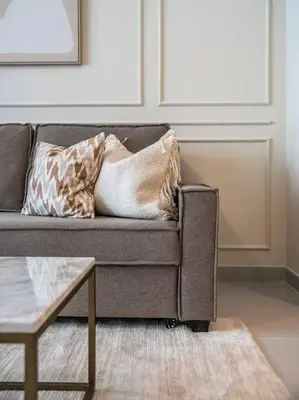 a couch with pillows on it in a living room at Sunset Creek Oasis: 1BR Gem Luxury Beach Apartment in Dubai