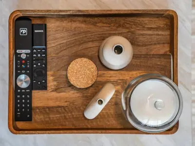 a wooden tray with a remote control and other items at Sunset Creek Oasis: 1BR Gem Luxury Beach Apartment in Dubai