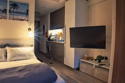 a bedroom with a bed and a flat screen tv at Stylish Studio Retreat in Dubai