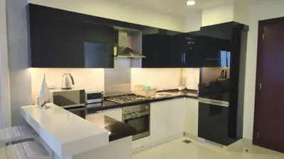 a kitchen with black and white cabinets and appliances at Damac Maison Mall Street - Downtown by Golden Casa in Dubai