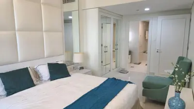 a bedroom with a large bed and two chairs at Damac Maison Mall Street - Downtown by Golden Casa in Dubai