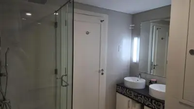 a bathroom with a glass shower and a sink at Damac Maison Mall Street - Downtown by Golden Casa in Dubai