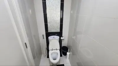 a small bathroom with a toilet in a stall at Damac Maison Mall Street - Downtown by Golden Casa in Dubai