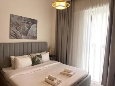 a bedroom with a bed with two towels on it at Pearl of Creek Beach: 1BR Luxury Beach Apartment in Dubai