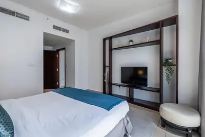 a bedroom with a large bed and a television at Cozy 1 Bedroom apartment I Downtown Dubai I Near Burj Khalifa in Dubai