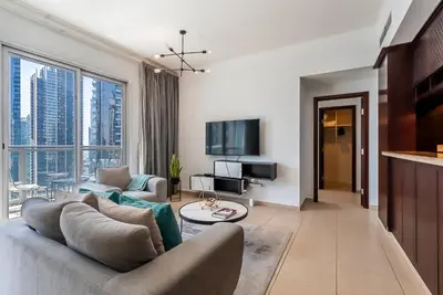 a living room with a couch and a tv at Cozy 1 Bedroom apartment I Downtown Dubai I Near Burj Khalifa in Dubai