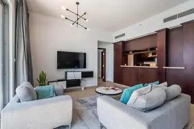 a living room with two couches and a tv at Cozy 1 Bedroom apartment I Downtown Dubai I Near Burj Khalifa in Dubai