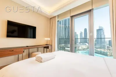 a hotel room with a bed and a large window at Address Residences Dubai Opera - Burj Khalifa & Fountain View, Downtown Dubai in Dubai