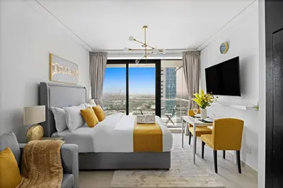 a bedroom with a bed and a desk and a tv at Newly Furnished Studio in JLT in Dubai