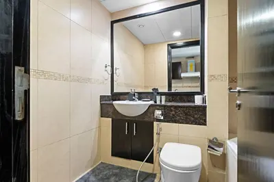 a bathroom with a sink and a toilet and a mirror at Newly Furnished Studio in JLT in Dubai