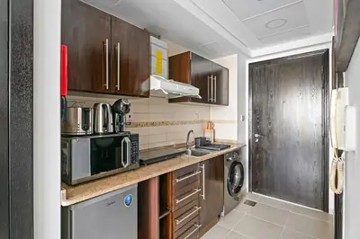 a kitchen with a sink and a microwave at Newly Furnished Studio in JLT in Dubai