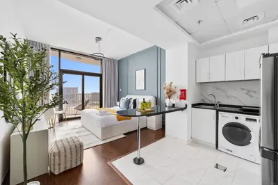 a kitchen and living room with a couch and a table at Silkhaus Luxury Studio Near Silicon Shopping Mall in Dubai