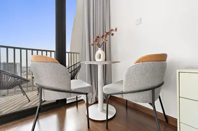 two chairs and a table in a room with a balcony at Silkhaus Modern Studio near Silicon Shopping Mall in Dubai