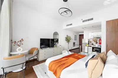 a bedroom with a large bed and a kitchen at Silkhaus Modern Studio near Silicon Shopping Mall in Dubai