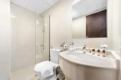 a white bathroom with a sink and a toilet at Silkhaus Modern Studio near Silicon Shopping Mall in Dubai
