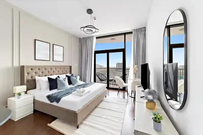 a white bedroom with a large bed and a mirror at Modern Luxurious Studio in Dubai Silicon Oasis in Dubai