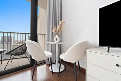 a living room with a table and chairs and a television at Modern Luxurious Studio in Dubai Silicon Oasis in Dubai