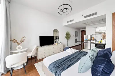 a bedroom with a king sized bed and a kitchen at Modern Luxurious Studio in Dubai Silicon Oasis in Dubai