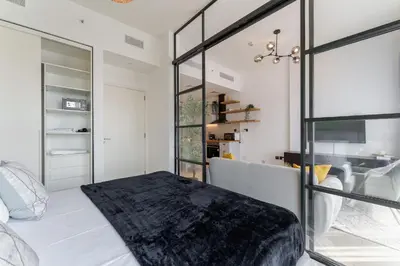 a bedroom with a bed and a glass wall at Cozy One Bedroom Near Dubai Hills Mall in Dubai