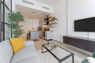 a living room with a couch and a tv at Cozy One Bedroom Near Dubai Hills Mall in Dubai