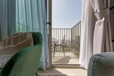 a room with a sliding glass door to a balcony at Cozy One Bedroom Near Dubai Hills Mall in Dubai