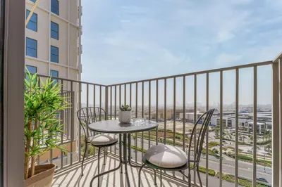 a balcony with a table and chairs and a view at Cozy One Bedroom Near Dubai Hills Mall in Dubai