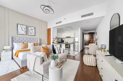 a white living room with a bed and a couch at Silkhaus Chic Studio Near Silicon Oasis Shopping Mall in Dubai