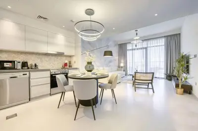 a kitchen and dining room with a table and chairs at Cozy 1BR Haven in The Cove, Dubai Creek Harbour in Dubai