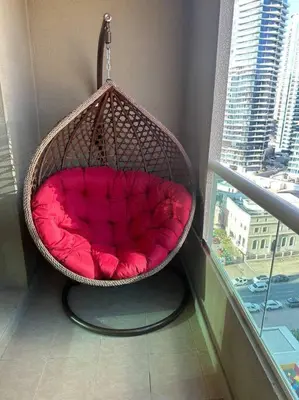 a hanging basket chair in a room with a window at Fantastic Apartment near Metro and jbr beach in Dubai