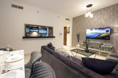 a living room with a couch and a tv at Spectacular 1BHK near Dubai Mall in The Lofts East - TrueBleu Homes in Dubai