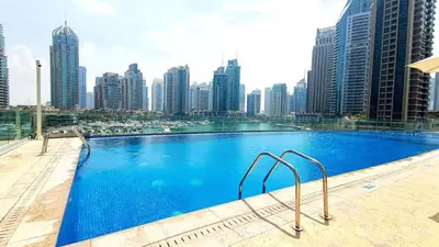 a large swimming pool with a city skyline in the background at Cayan Tower Dubai Marina - By Home Of Choice in Dubai