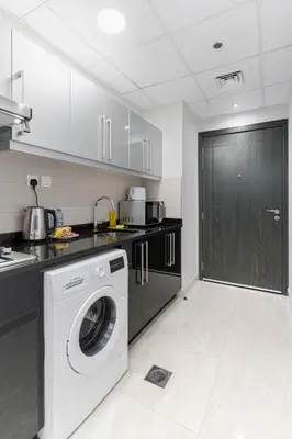 a kitchen with a washer and a washing machine at Modern Studio with Canal View in Business Bay in Dubai