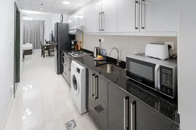a kitchen with a sink and a washer and dryer at Modern Studio with Canal View in Business Bay in Dubai