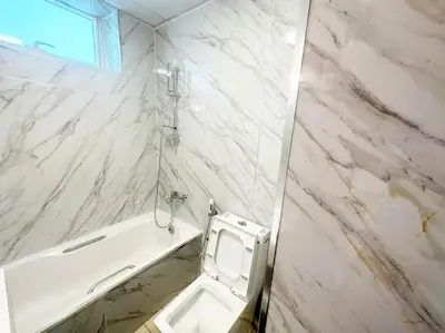 a white marble bathroom with a toilet and a sink at Lux 1BR w rooftop pool in Marina near metro, Beach in Dubai