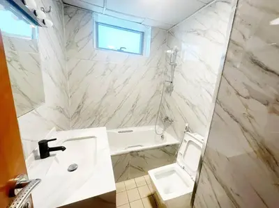 a white bathroom with a sink and a toilet at Lux 1BR w rooftop pool in Marina near metro, Beach in Dubai