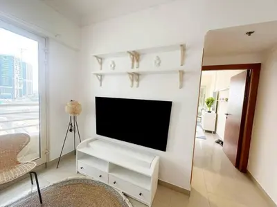 a living room with a flat screen tv on a wall at Lux 1BR w rooftop pool in Marina near metro, Beach in Dubai