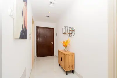 a hallway with white walls and a wooden door at Dubai Marina - 1BHK Apartment in Dubai