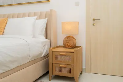 a bedroom with a bed and a night stand with a lamp at Dubai Marina - 1BHK Apartment in Dubai