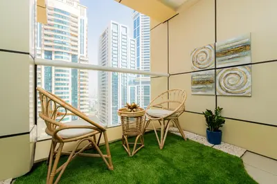 a balcony with two chairs and a table at Dubai Marina - 1BHK Apartment in Dubai