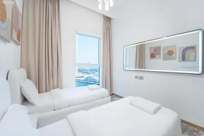 a living room with white furniture and a large window at Fabulous Missoni Designer Building, 3 bedroom plus maid in Dubai