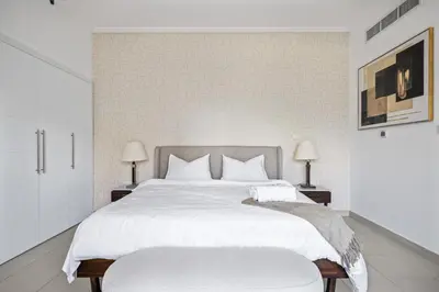 a bedroom with a large white bed and two lamps at Skyline Retreat - South Ridge 2 - Downtown Dubai in Dubai