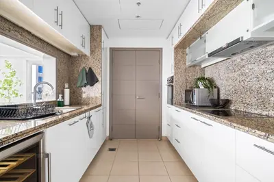 a kitchen with white cabinets and a door at Skyline Retreat - South Ridge 2 - Downtown Dubai in Dubai