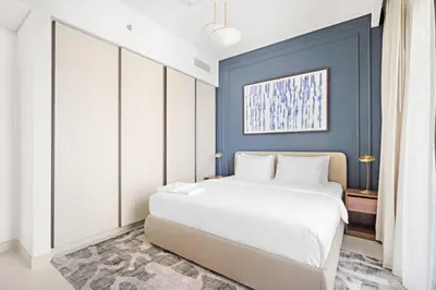 a bedroom with a white bed and a blue wall at Silkhaus Sea & City View 1BDR in Exclusive Neighbourhood in Dubai