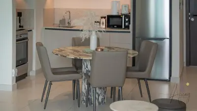 a kitchen with a table with chairs and a refrigerator at Sky-High 1BR RetreatMarina VistaEmaar Beachfront in Dubai