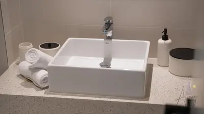 a white sink with a faucet on top of a counter at Sky-High 1BR RetreatMarina VistaEmaar Beachfront in Dubai