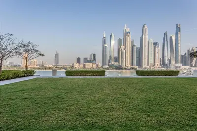 a park with a view of a city skyline at Sky-High 1BR RetreatMarina VistaEmaar Beachfront in Dubai