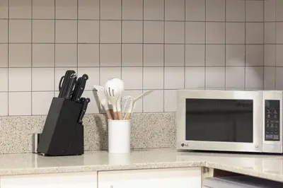 a kitchen counter with a microwave and some utensils at Apartment KOYO in the heart of JBR Beach - 3BDR in Dubai
