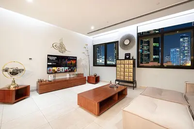 a living room with a couch and a tv at Apartment KOYO in the heart of JBR Beach - 3BDR in Dubai