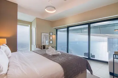 a bedroom with a large bed and a large window at Address JBR 2 Bedroom With Beach Access by Millennium Vacation Homes in Dubai